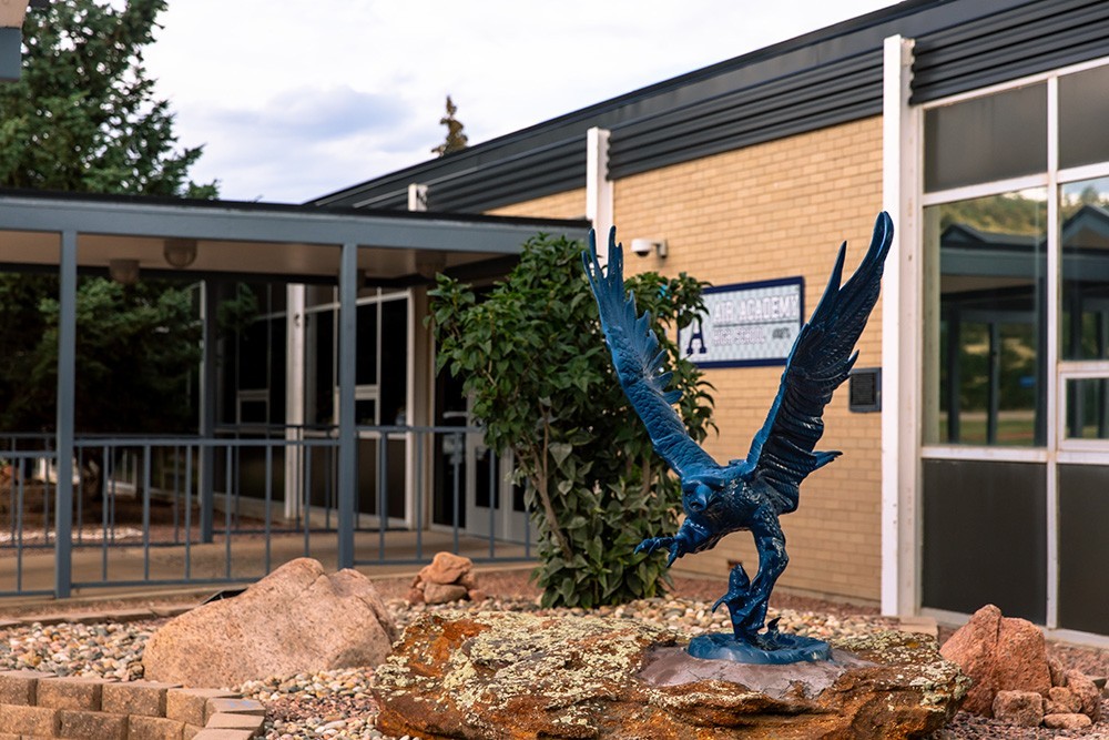 A statue of a blue falcon outside the entrance to Air Academy High School.